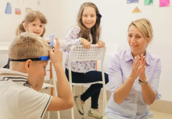 Dzieci uczestniczą w zabawie językowej prowadzonej przez nauczycielkę