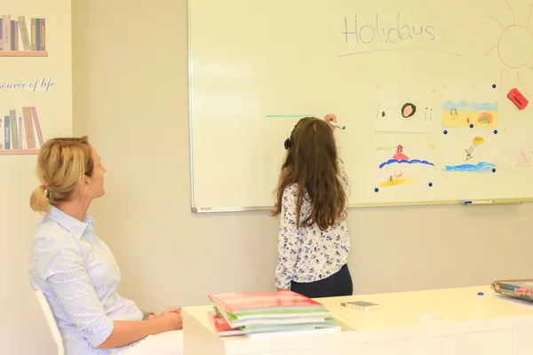 Dwoje dzieci pracuje przy tablicy podczas lekcji angielskiego